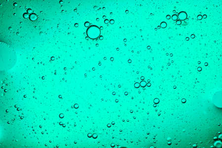 close-up view of a light green liquid background of moving bubblesの写真素材
