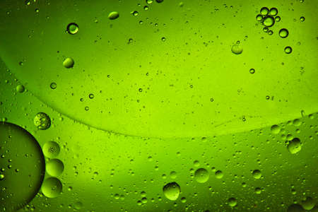 close-up view of a green liquid background of moving bubblesの写真素材