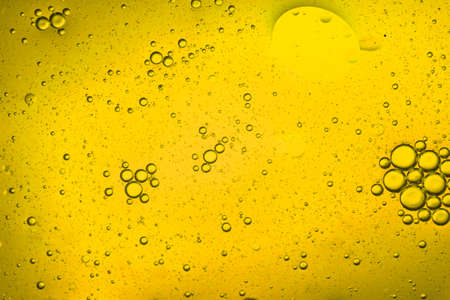 close-up view of a yellow liquid background of moving bubblesの写真素材