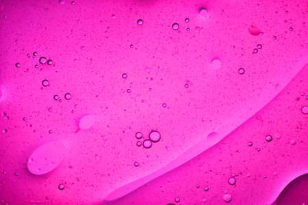 close-up view of a pink liquid background of moving bubblesの写真素材