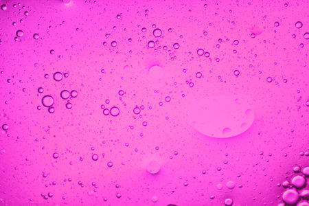 close-up view of a soft pink liquid background of moving bubblesの写真素材