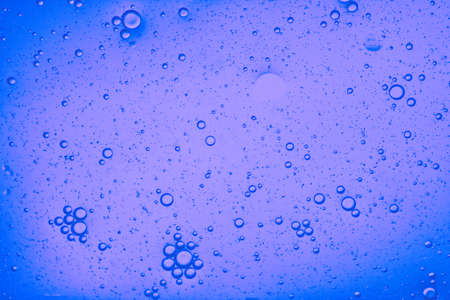 close-up view of a bluish liquid background of moving bubblesの写真素材