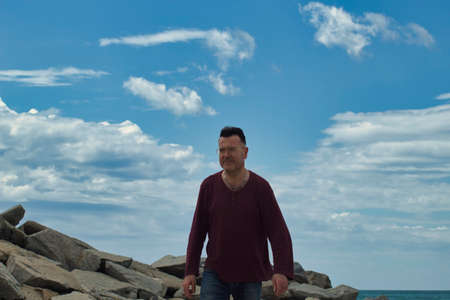 lonely man on the beach walking to foregroundの写真素材
