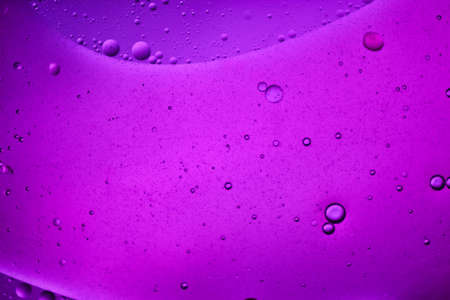 close-up view of a loose purple liquid background of moving bubblesの写真素材