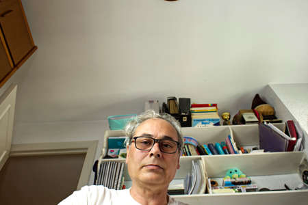 mature man in room placing things in a drawer seen from insideの写真素材