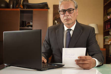 businessman teleworking from home with laptop due to restrictionsの写真素材