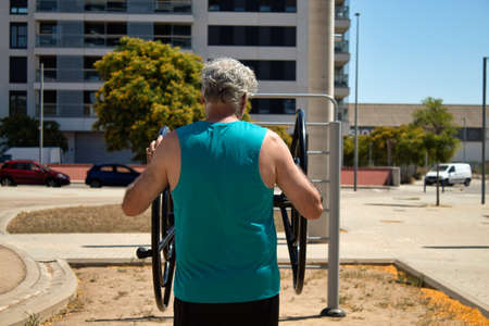 mature man exercising arms with street machineの写真素材
