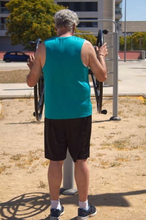 mature man exercising arms with street machine