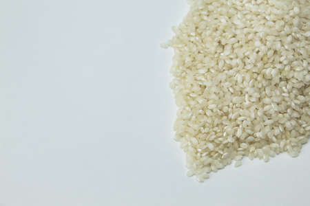 view from above of heap of white rice on white background with copy spaceの写真素材