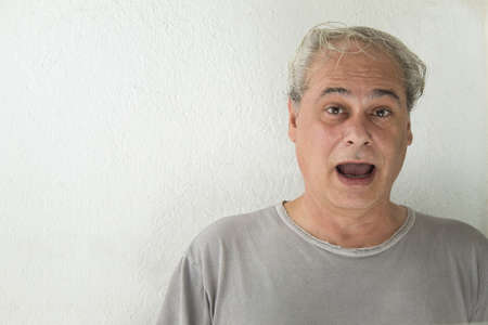 mature man looking straight ahead at camera on white backgroundの写真素材