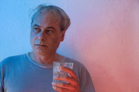 mature man with red and blue ambient color lights on a white backgroundの写真素材