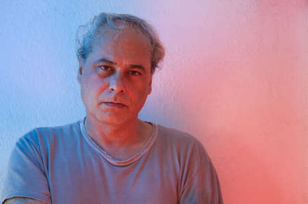 mature man with red and blue ambient color lights on a white backgroundの写真素材