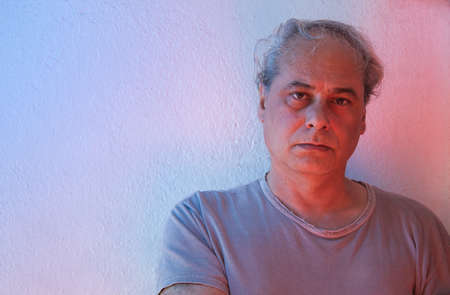 mature man with red and blue ambient color lights on a white backgroundの写真素材