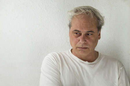 portrait of mature man with gray hair in white shirt on a white backgroundの写真素材