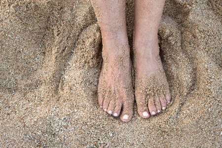 top view of feet of the woman in the sand of the beachの写真素材