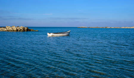 Boat drifting on sea in sunset light