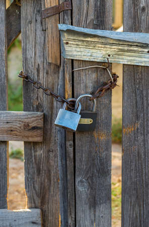 Wooden gates closed with a chain with double lock .の写真素材