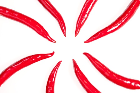 Eight red chilies pointing towards the centerの写真素材