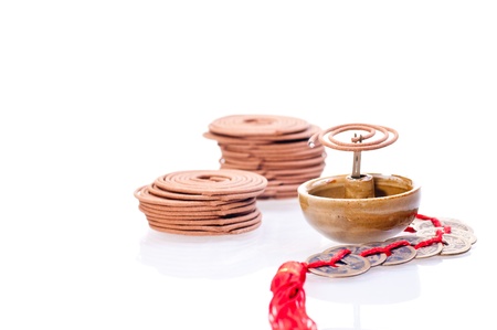 Mini incense coil burning with stack of coils and chinese old coins at the backgroundの写真素材