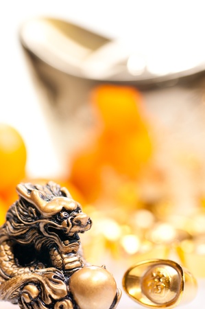 Chinese new year with large ingot, mandarin oranges and dragon statue close upの写真素材
