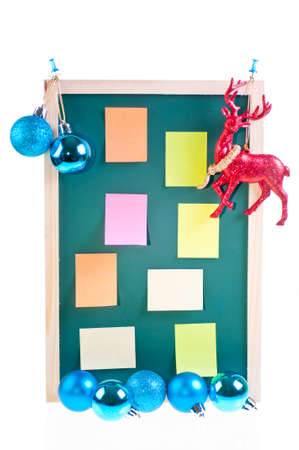 Christmas notice board with Christmas blue baubles, ornament and sticky notes on the boardの写真素材