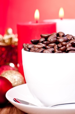 Christmas coffee beans in a cup over red background and Christmas decorationsの写真素材
