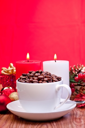 Christmas coffee beans in a cup over red background and Christmas decorationsの写真素材