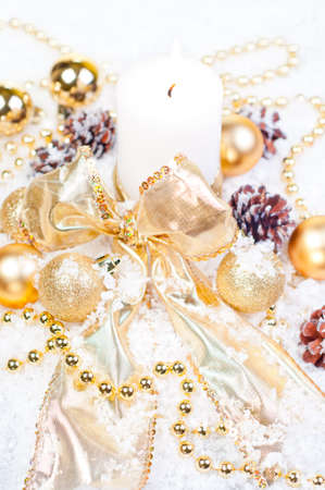 Gold Christmas theme on snow with pinecones and gold decorationsの写真素材