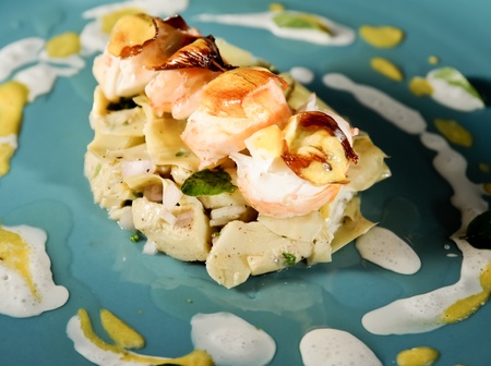 Italian grill lobster and artichoke dish on a blue plateの写真素材