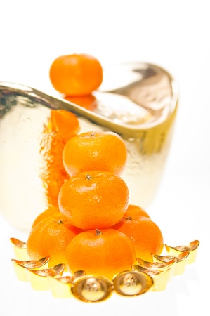 A stack of tangerine with large ingot as backgroundの写真素材