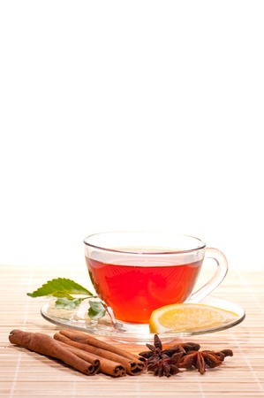 Hot lemon tea in a glass cup and spices on a bamboo matの写真素材
