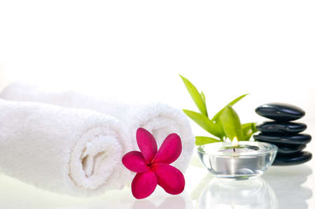 Spa concept with black zen stones and red flower over white backgroundの写真素材