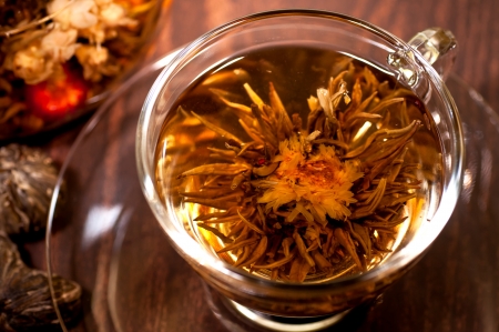 Blooming tea close up in a cup on the wooden tableの写真素材