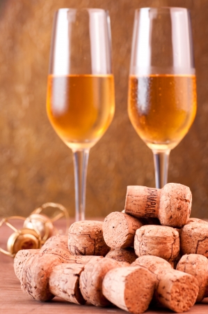 Pile of champagne corks with two glasses of champagne at the backgroundの写真素材