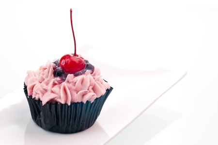 Cherry cup cake close up on a white plateの写真素材