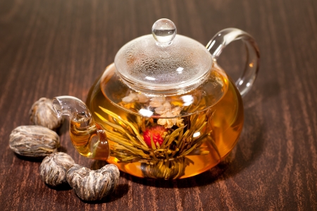 Blooming tea in a glass teapot with variety of hand made teasの写真素材