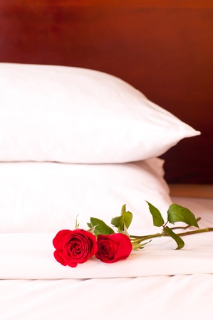 Romantic setting on a bed with red roses の写真素材