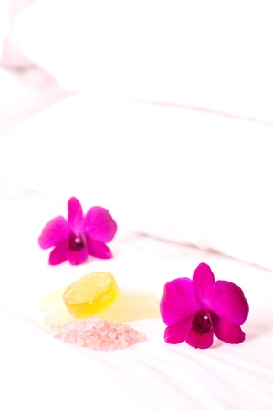 Spa concept orchids, bath soap and bath salt on hotel bed close upの写真素材