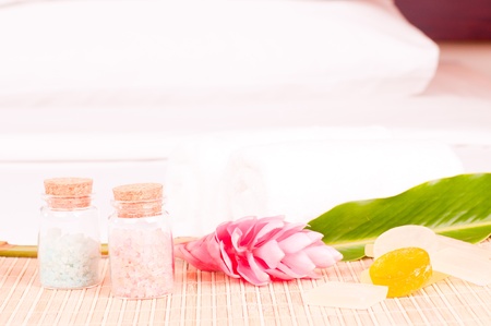 Spa holiday on a hotel bed with a pink ginger flower and bath saltsの写真素材