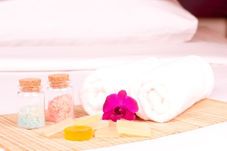 Spa holiday on a hotel bed with orchid, bath salts and soapsの写真素材
