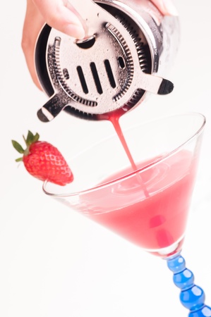 Pouring a Strawberry Daiquiri into a cocktail glassの写真素材