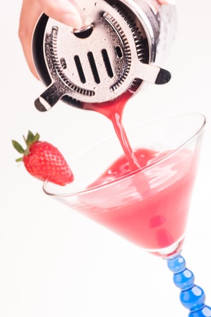 Pouring a Strawberry Daiquiri into a cocktail glassの写真素材