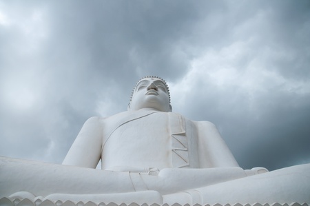 Meditating Buddha statue with clouds background at Athugala, Sri Lankaの写真素材
