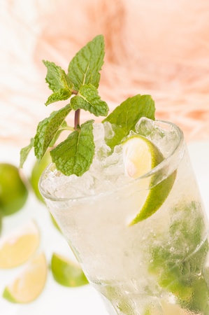 Lime Mojito cocktail close-up with a straw hat background,  a Cuban cocktail made with cuban rum, lime, sugar and a splash of sodaの写真素材