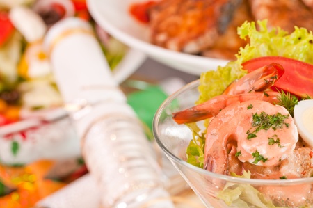 Prawn cocktail close-up with a  variety of festive cuisine at the background