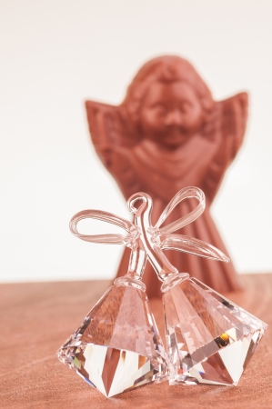 Crystal Bells ornament close-up with chocolate Angel at the backgroundの写真素材