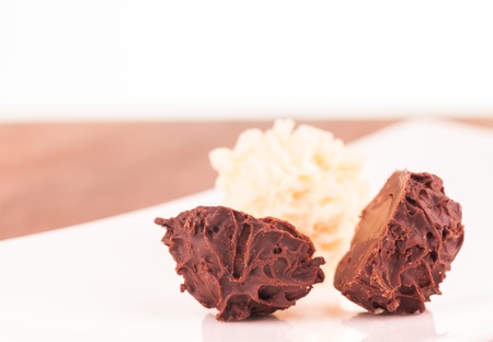 Dark chocolate truffle in half extreme close up with white chocolate truffle backgroundの写真素材