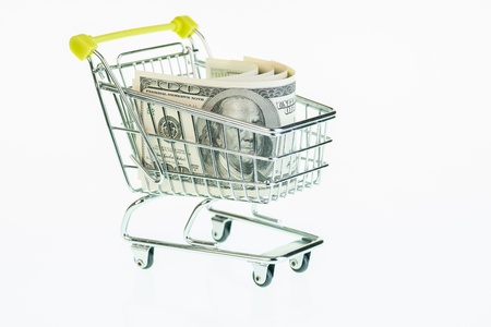 American one hundred dollar banknotes in shopping cart over white backgroundの写真素材