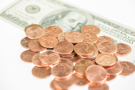 American pennies piled up on one hundred dollar bill の写真素材