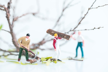 Miniature workmen cutting trees close upの写真素材